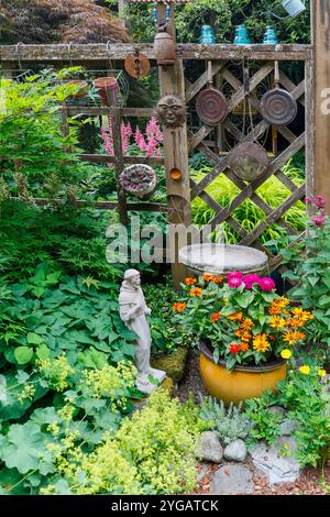 USA, Bundesstaat Washington, Sammamish. Garten mit Zaun und Blumentöpfen. Vogelbad und Gartenkunst und Topf mit Zinnien Stockfoto