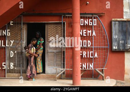 Porto Novo, Benin. Januar 2022. Zwei beninesische Frauen hängen vor dem ehemaligen „King“-Kino in Porto-Novo ab. Die Entwicklung der digitalen Technologie in Benin hat die Schließung von Kinos beschleunigt. Die letzten Kinos des Landes wurden in Cafés, Gotteshäuser und Fitnessstudios verwandelt. Bis 2022 war nur noch ein Kino im Besitz des französischen Milliardärs Vincent Bolloré in Betrieb: Das Canal Olympia in der Hauptstadt Cotonou. Quelle: SOPA Images Limited/Alamy Live News Stockfoto