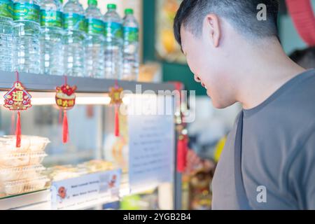 Chinesisches malaysisches Paar im Alter von 30 Jahren genießt lokale Cendol in einem bei Einheimischen beliebten Geschäft in Kuala Lumpur, Malaysia. Stockfoto