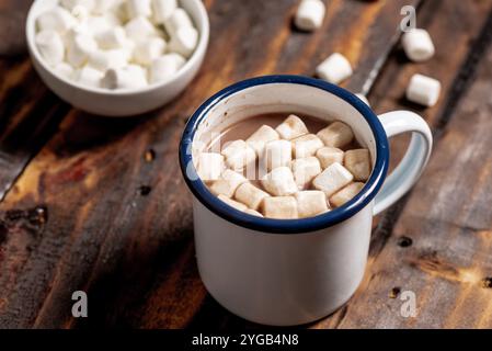 Heißer Kakao im weißen Emailbecher mit Marshmallows. Stockfoto