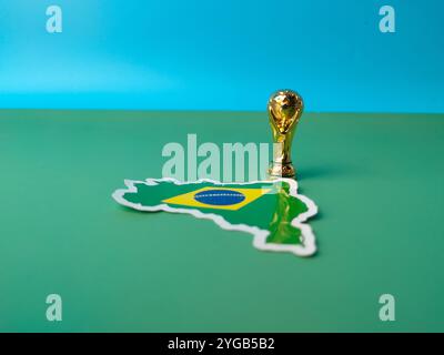 Perak, Malaysia-23. August 2024: Top View brasilianische Flaggenaufkleber mit WM-Trophäe auf grünem Hintergrund. Stockfoto