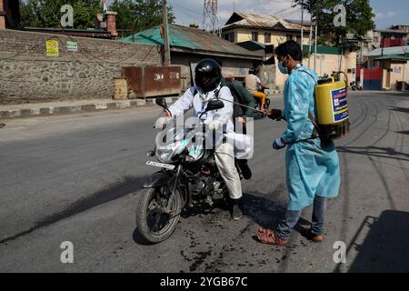 Ein NGO-Arbeiter desinfiziert ein Fahrzeug in Srinagar, Indien verwaltet Kaschmir am 3. Mai 2021. Jammu und Kaschmir verzeichnen 51 Todesfälle, was die höchste Zahl an COVID-19-Todesfällen in der Region ist. Indien meldete jedoch fast 370.000 neue covid-19-Fälle und 3421 neue Todesfälle. Stockfoto