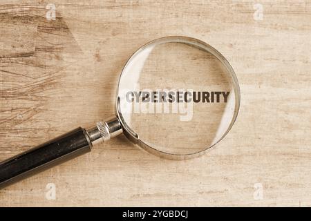 Das Konzept von Technologie und Entwicklung. Phrase, Wörter, Text CYBERSICHERHEIT durch eine Lupe, Draufsicht. Stockfoto
