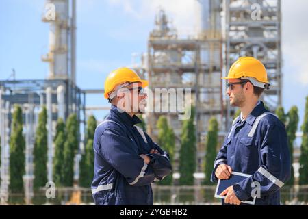 Ingenieure in der Erdölindustrie arbeiten im Freien. Der Leiter der Raffinerieöl- und Gasdienstleister arbeitet mit der Instandhaltung komplexer Gasrohrgebäude Stockfoto