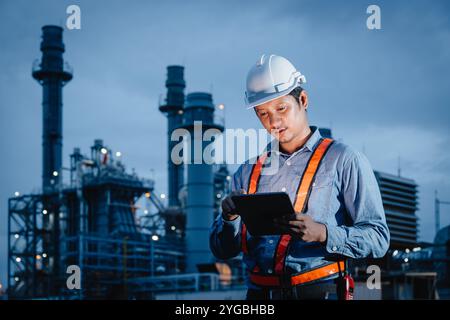 Professioneller Ingenieur Männlich, Der Nachts Bei Der Raffinerieindustrie Arbeitet. Umfrage Zum Thema Kraftwerksbau – Werksangehörige Am Abend. Stockfoto