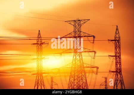 Stromkabel, Hochspannungsleitung Pylon, Silhouette vor Sonnenuntergang Himmel Dämmerung Dämmerung. Stockfoto