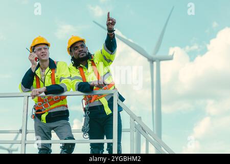 Das Team der Techniker mischt männliche Arbeiter, die bei Wind Turbines arbeiten, auf dem Feld des Windenergieerzeugers im Keller. Stockfoto