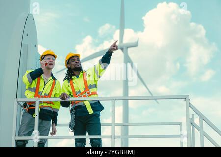 Das Team der Techniker mischt männliche Arbeiter, die bei Wind Turbines arbeiten, auf dem Feld des Windenergieerzeugers im Keller. Stockfoto