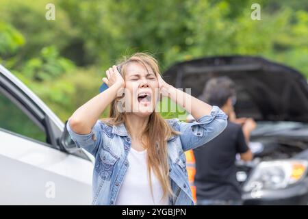 Frauen legen Wert auf Schreie aufgrund von Autoproblemen, Fahrten, kaputten Autos oder Fahrzeugunfall am Straßenrand. Stockfoto