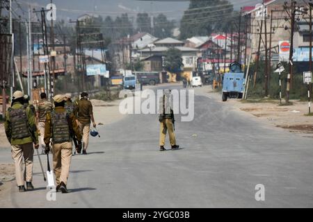 Indische paramilitärische Truppen stehen auf einer verlassenen Straße während eines Waffenschlages zwischen Indianern und Militanten in der Gegend von Pampore im Bezirk Pulwama südlich von Srinagar, dem indianischen Kaschmir am 16. Oktober 2021, in Alarmbereitschaft. Zwei Militante wurden bei der Schießerei getötet, jedoch wurden vier Wohnhäuser beschädigt, von denen eines von indischen Truppen gesprengt wurde. Stockfoto
