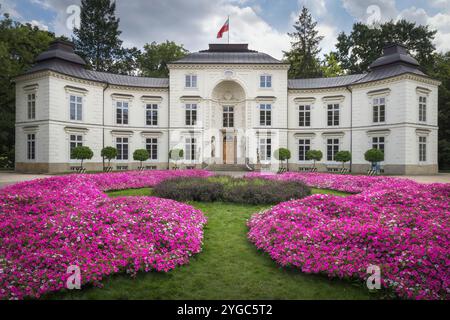 Der Mylewicki-Palast steht anmutig, geschmückt mit leuchtenden Blumen, die die Schönheit der Natur zeigen, in Warschau, Polen Stockfoto