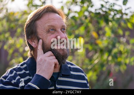 Porträt eines denkenden oder überraschten Seniorenmannes. Ältere bärtige kaukasische Männer in der Natur. Stellen Sie sich bärtigen männlichen Träumen, Probleme zu lösen, Nahaufnahme Stockfoto