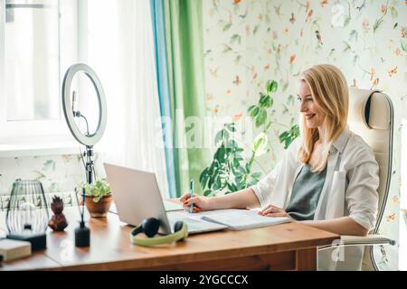 Ideale Umgebung mit einer Ringleuchte, die den Schreibtisch und das Notebook für die Erstellung von Inhalten beleuchtet Stockfoto