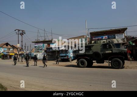 Indische paramilitärische Truppen stehen auf einer verlassenen Straße während eines Waffenschlages zwischen Indianern und Militanten in der Gegend von Pampore im Bezirk Pulwama südlich von Srinagar, dem indianischen Kaschmir am 16. Oktober 2021, in Alarmbereitschaft. Zwei Militante wurden bei der Schießerei getötet, jedoch wurden vier Wohnhäuser beschädigt, von denen eines von indischen Truppen gesprengt wurde. Stockfoto