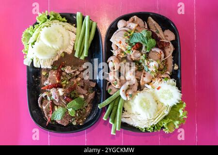 Larb Moo oder thailändischer würziger Hackfleisch-Salat mit Eingeweide und Larb Tub Wan oder thailändischer würziger Schweineleber-Salat, ein lokales Isan-Essen im Nordosten von Stockfoto