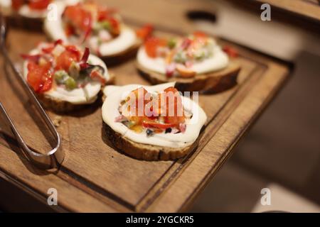 Genießen Sie köstliche Gourmet-Crostini mit verschiedenen frischen Toppings und einem cremigen Aufstrich Stockfoto