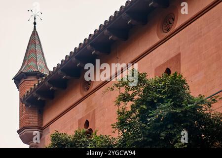 Detailliertes Bild des Turms des Stadtgebäudes von Viladecans mit kunstvollem Backsteindesign und lebendigen Dachziegeln, die die Architektur der Stadt hervorheben Stockfoto