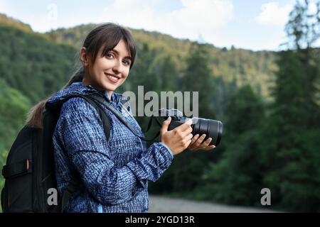 Lächelnder Fotograf mit Rucksack und Kamera im Freien Stockfoto