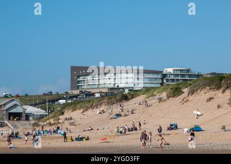 Fistral Blue Apartmentblock mit Blick auf den geschäftigen Fistral Beach an einem sonnigen Tag in Newquay, Cornwall, Großbritannien Stockfoto