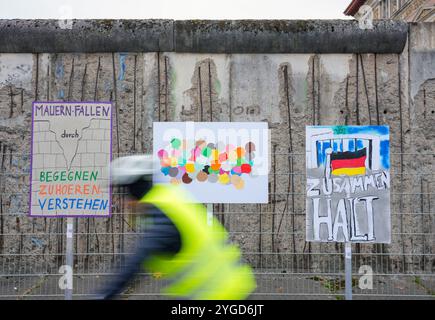 Berlin, Deutschland. November 2024. Plakate zum Gedenken an 35 Jahre friedliche Revolution und den Mauerfall am 9. November 1989 hängen in der Niederkirchner Straße vor den Mauerresten vor dem Dokumentationszentrum Topographie des Terrors. Quelle: Soeren Stache/dpa/Alamy Live News Stockfoto