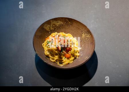 Spaghetti Carbonara Pasta Ei und Käse cremige Cremesauce mit Garnelen und Mikrokräuterdekor auf der Oberseite der Steinschale im Studio Stockfoto