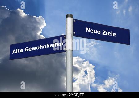 Straßenschild vor dem bewölkten Himmel, das die Wahl zwischen ? Alte Gewohnheiten? (Alte Gewohnheiten) und ? Neue Ziele? (Neue Ziele) auf Deutsch Stockfoto