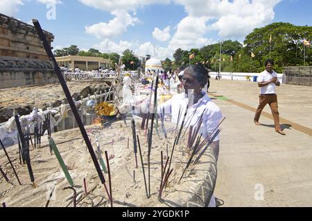 Sri-lankische Pilger zünden Weihrauchstäbchen an der weißen Stupa in der heiligen Stadt Anuradhapura, Nordzentralprovinz, Sri Lanka, Asien Stockfoto