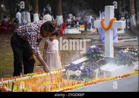 Menschen aus der christlichen Gemeinde zünden Kerzen an und beten auf dem Grab ihres Verwandten während der All Sels Day Observation in Guwahati, Indi Stockfoto