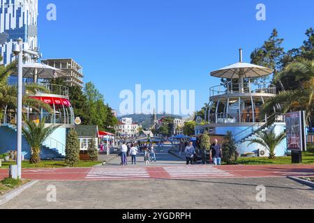 Batumi, Georgia, 30. April 2017: Menschen, die im Park mit Palmen in der Nähe der Promenade Boulevard des georgianischen Sommerresorts in Asien spazieren Stockfoto