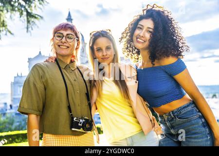 Porträt von drei jungen Reisenden mit Digitalkamera in einem Stadtaussichtspunkt bei Sonnenuntergang Stockfoto