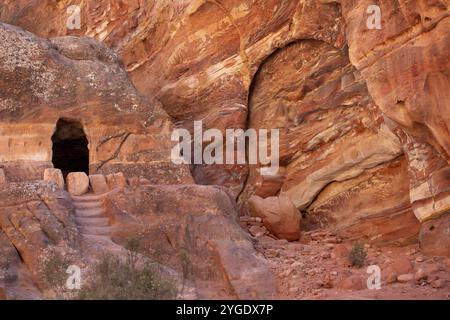 Petra, Jordanien, mehrfarbige Sandsteinfelsen und Mineralschichten und Höhle in alten Gräbern auf dem Wadi Farasah Trail Stockfoto