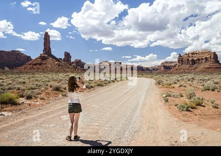 Junge Frau, die ein Foto in einer Wüstenlandschaft Stockfoto