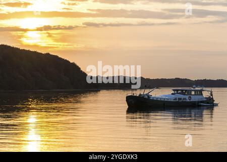 Boot vor der Küste der Ostsee bei einem schönen bunten Sonnenuntergang ankern Stockfoto