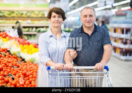 Älteres Ehepaar kauft Tomaten im alkoholischen Bereich eines Supermarktes Stockfoto