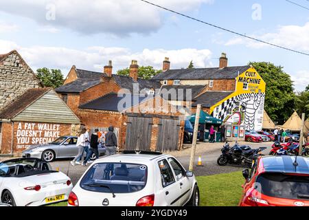 Ettington, Großbritannien - 5. Juni 2024: Leute gehen zu Fuß zum beliebten Treffpunkt für Coffein and Machine the Hill Car Enthusiasten. Stockfoto