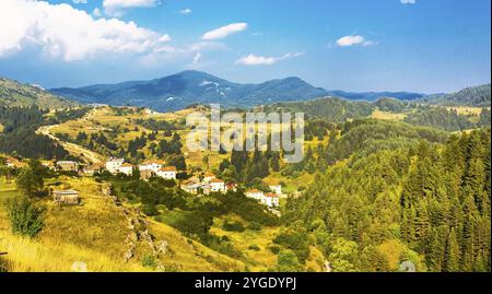 Aerale Ansicht des kleinen bulgarischen Dorfes in Rhodope. Berge und Wälder Landschaft im Hintergrund Stockfoto