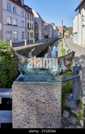 Bronzeskulptur eines Wildschweins am Fluss in städtischer Umgebung, Schweinebrücke mit einer Gruppe von vier Schweinen auf den Geländerpfosten, geschaffen 1989 durch Sculpt Stockfoto