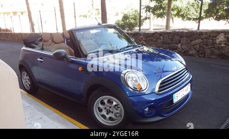 SPANIEN, TENERIFFA - 19. JULI 2014: Playa Paraiso. Stilvolles blaues Cabriolet auf der Sunny Street. Ein blaues Cabriolet steht auf einem sonnigen Stree Stockfoto