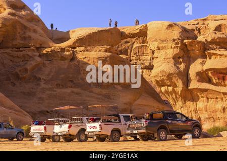 Jordanien, Wadi Rum, 2. November 2022: Beduinen-Jeep-Tourwagen in der Nähe der Steinbrücke um Frouth, Wüste mit felsigen Felsen im Hintergrund, A Stockfoto