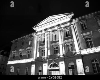 Ein großartiges historisches Gebäude steht bei Nacht beleuchtet und zeigt seine architektonischen Details und majestätischen Säulen. Das Licht verstärkt seine Schönheit unter dem dunklen Himmel Stockfoto