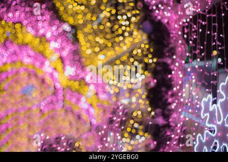 Leuchtende bunte Weihnachtslichter auf schwarzem Hintergrund, Überlagerung Stockfoto