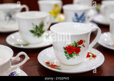 Cmielow, Polen, 29.12.2024 Set aus weißen Porzellanbechern und Untertassen mit bunten Blumenabdrücken, hergestellt in AS Cmielow Fabrik Stockfoto