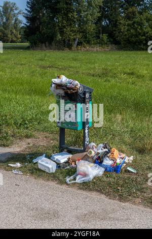 Überlaufender Mülleimer in einem Park Stockfoto