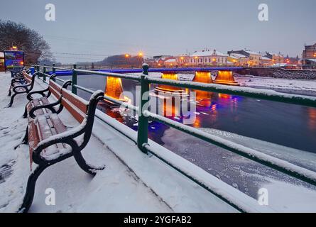 uschhorod, ukraine - 26. Dezember 2016: Urbane Landschaft mit Flussufer bei Sonnenaufgang. Wunderschöne Aussicht. Winterferien Stadtbild. Das Licht der Innenstadt spiegelt sich in der wider Stockfoto