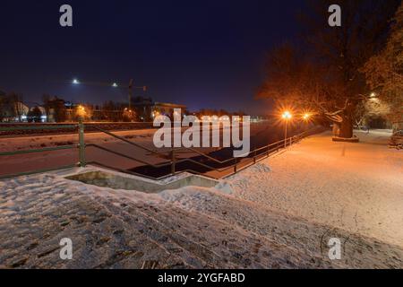 uschhorod, ukraine - 26. Dezember 2016: Urbane Landschaft mit Flussufer bei Sonnenaufgang. Weihnachtszeit. Winterferien Stadtbild. Das Licht der Innenstadt spiegelt sich in der wider Stockfoto