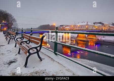 uschhorod, ukraine - 26. Dezember 2016: Urbane Landschaft mit Flussufer bei Sonnenaufgang. Wahrzeichen der Architektur. Winterferien Stadtbild. Das Licht der Innenstadt reflektiert Stockfoto