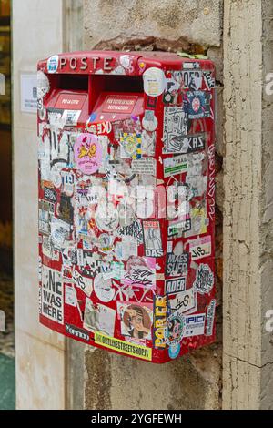 Venedig, Italien - 9. Oktober 2024: Italienisches Postfach an der Wand mit Klebeaufklebern verdeckt Vandalismusschäden. Stockfoto