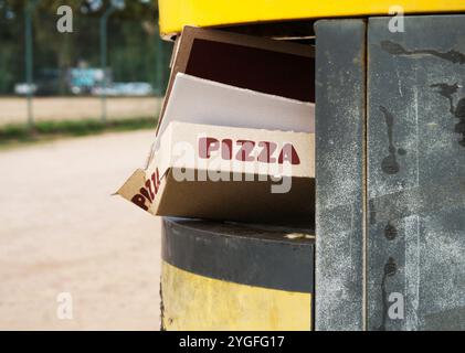 Pizzakarton in überlaufendem Mülleimer Stockfoto