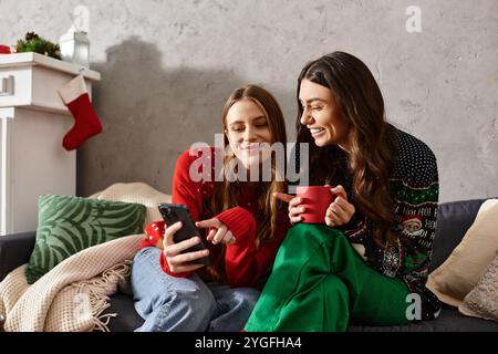Zwei Freunde in festlichen Pullover teilen sich Lachen und Feiertagsstimmung, während sie die gemütliche Atmosphäre zu Hause genießen. Stockfoto