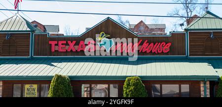 PIGEON FORGE, TN - 12. März 2024: Schild mit dem Texas Roadhouse auf der Außenseite des Restaurantgebäudes. Stockfoto